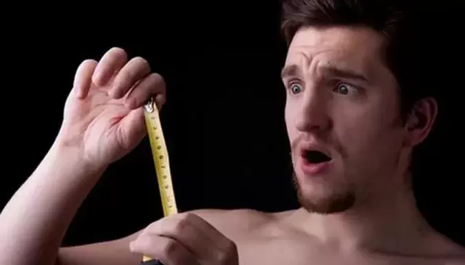 a man measures his penis before enlargement